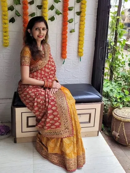 A seated pose in the "Infinity Drape," showing how the pleats and layers fall gracefully. This style works beautifully with sarees that have rich borders and patterns.