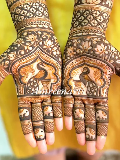 A close-up of palms adorned with peacocks in jharokhas and tiny elephants on the fingers.