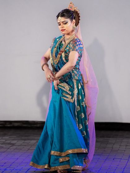 A side profile capturing a moment of contemplation as Radha. The costume, jewellery, and hairstyle are all integral parts of building the character for a stage production.