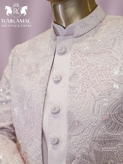 A close-up of the intricate floral beadwork and handcrafted buttons on the white Indo-Western jacket.