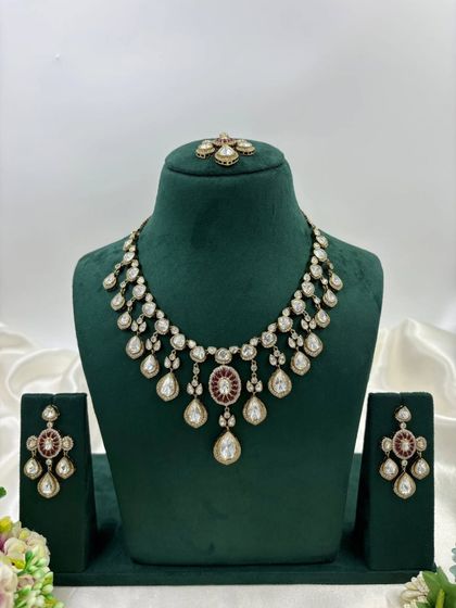 A close-up of the earrings and tikka from our Moissanite Kundan set. This highlights the fine craftsmanship and the combination of red and white stones.