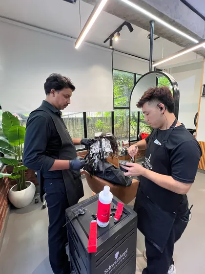 The coloring process requires precision and teamwork. Here, two of my stylists are working together on a balayage application.