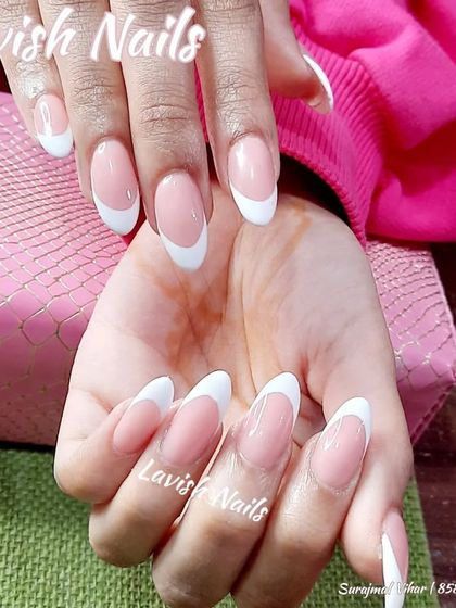 A close-up view of a classic French manicure on long almond nails, highlighting the perfect shape and finish.