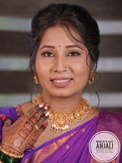 A close-up of Akshaya's Punyavachan look, showing the subtle makeup and the beautiful temple jewellery necklace. Her henna-adorned hands complete the look.