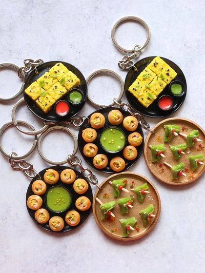 A collection of street food keychains, featuring pani puri and dhokla.
