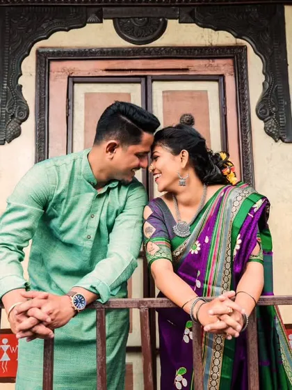 An intimate portrait set against the beautiful architecture of a traditional Maharashtrian wada. The setting perfectly complements their ethnic wear and the romantic mood.