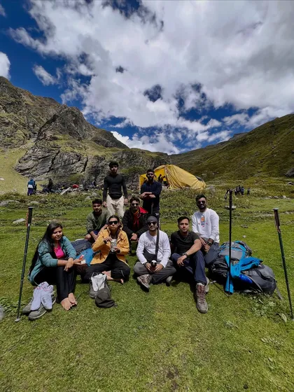 Taking a well-deserved break with the crew on the grassy meadows of the Hampta Pass trail.