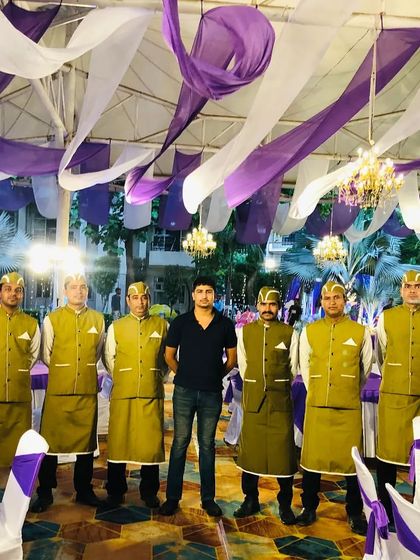 The full team, including the event supervisor, ready for service. We work as a cohesive unit to manage every aspect of the catering, from cooking to serving and clean-up.