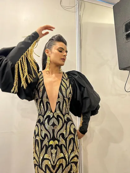 A backstage photo from the Jio World Plaza launch. This bold makeup look with a sharp eye and glowing skin was created for a showstopping black and gold gown.