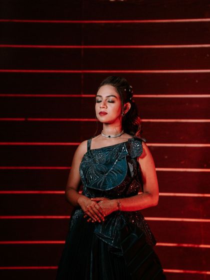A modern and stylish portrait of a bride in a unique blue gown for her Sangeet. The red-lined background adds a pop of color and drama.