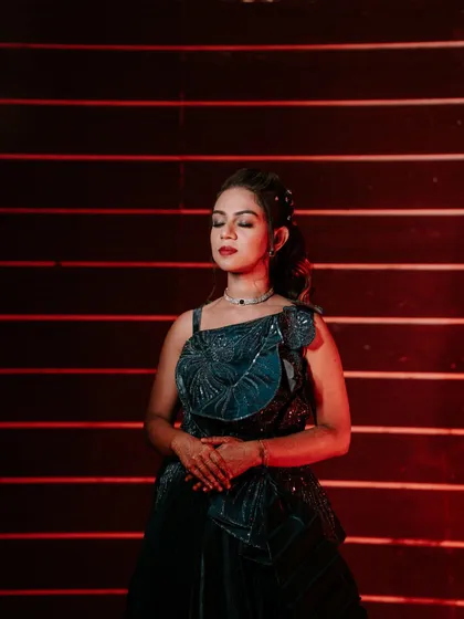 A modern and stylish portrait of a bride in a unique blue gown for her Sangeet. The red-lined background adds a pop of color and drama.