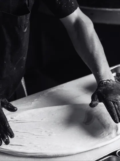 Spilling the secrets behind the scenes. My pizzaiolo stretches the dough, getting it ready for toppings.