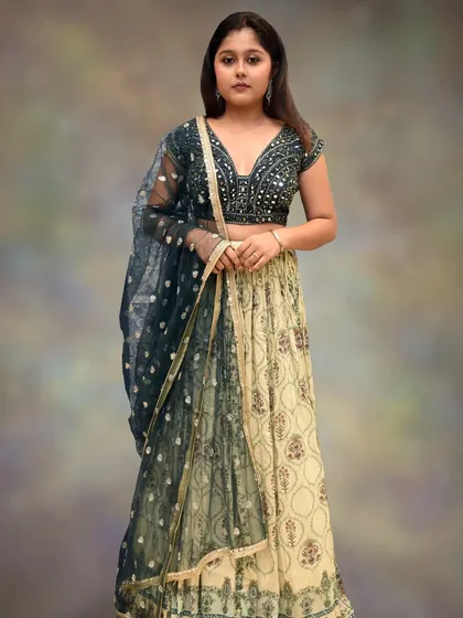 The full view of the bottle green and pastel yellow lehenga, showing the beautiful contrast and the delicate net dupatta.