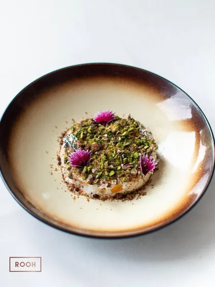The much-talked-about Mango Malai dessert from our Awadhi pop-up. This dish features creamy, reduced milk with fresh mango, topped with pistachios and silver leaf.