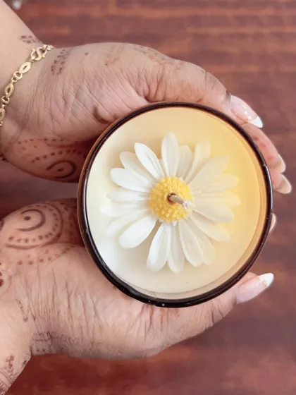The beautiful daisy flower on top of our scented candle. We pour each one by hand with great care and attention to detail.