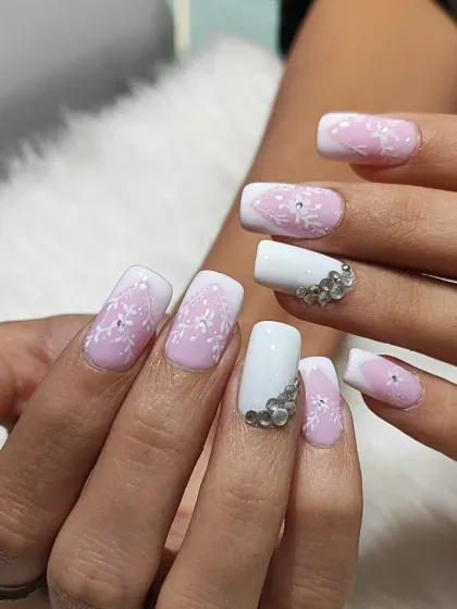 This angle showcases the delicate white floral line work and the sparkle of the rhinestones on the accent nail.