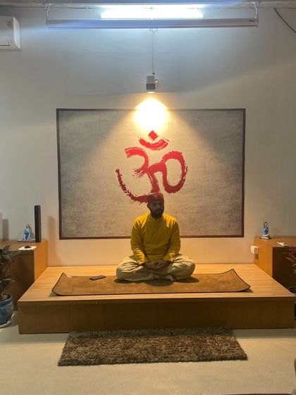 As a guru, I hold the space for my students to go deep into their meditation. Here, I am guiding a session from the front of the class, with the sacred symbol of Om behind me to amplify the energy.