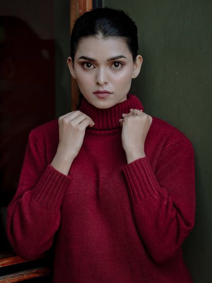 A classic portrait in a cozy turtleneck sweater. The rich red color and the model's direct gaze create a warm and inviting fall or winter look.
