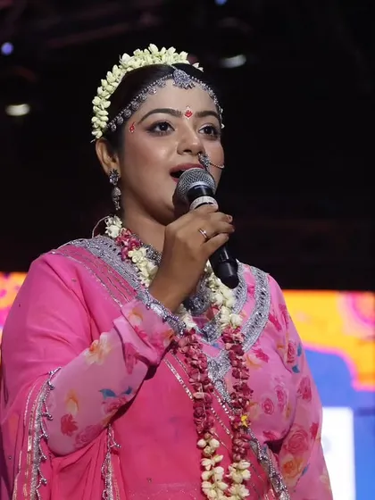 A close-up of me speaking into the microphone as Radha, fully in character.