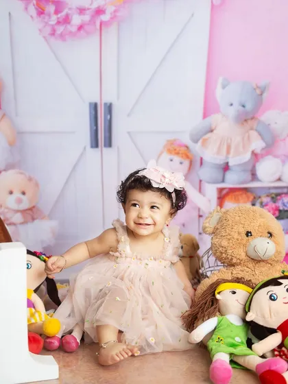 A little doll surrounded by her friends. Using your child's favorite toys in a shoot can make them feel comfortable and bring out their natural smiles.