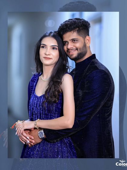 An elegant portrait of a couple in coordinated royal blue, with a soft, artistic frame.