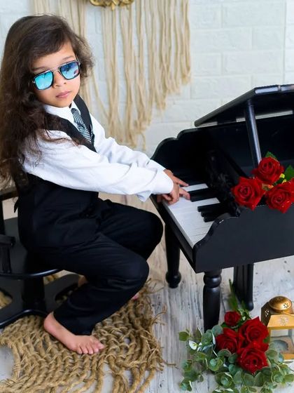 A little rockstar at the piano. This cool kid with his sunglasses and suit is ready to play a tune in this fun, music-themed session.