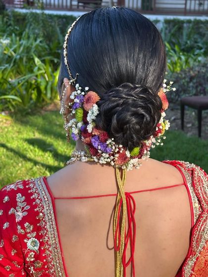 A beautiful floral bun for Kritika's wedding day. The colorful flowers add a touch of freshness and vibrancy to her regal bridal look.
