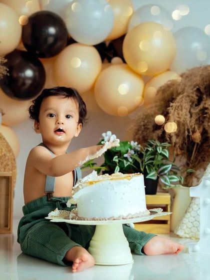 The aftermath of a successful cake smash. This little boy is enjoying his first taste of birthday cake in our popular bohemian-style studio set.