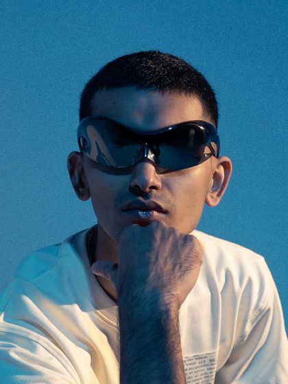 A tight close-up on the face, emphasizing the oversized, futuristic sunglasses. This shot is all about attitude and making the accessory the hero.