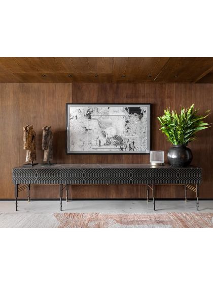 The pyrite-inlaid Laila Sideboard is a key feature in the Camellias lobby. Its intricate pattern and handcrafted detail are set against a warm wood-paneled wall, showcasing a blend of modern craft and timeless materials.