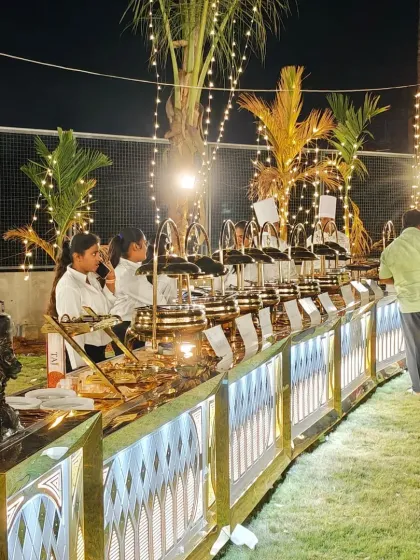A wide view of our premium buffet setup for a large wedding reception. We design elegant, illuminated counters that not only display the food beautifully but also enhance the overall decor of your special day.