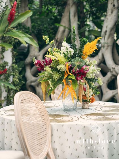 An elegant tablescape from the 'Garden of Gaia' baby shower, with tropical flowers and stylish chairs.