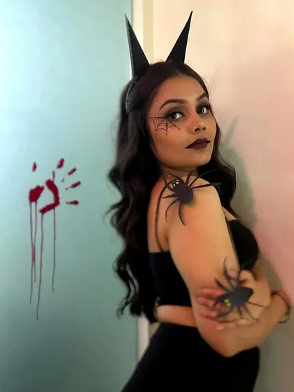 This shot shows the Halloween makeup from the side, giving a better view of the spiderweb detail on the cheek and the overall styling.