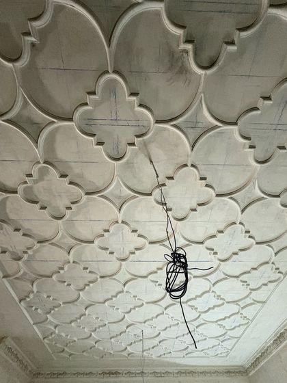 The intricate pattern of a coffered ceiling being created. This type of detailed ceiling work is a hallmark of classical design and adds a layer of sophistication and grandeur to a room.