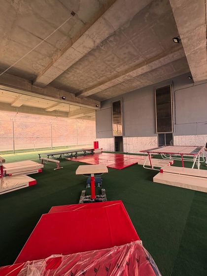 An overview of our gymnastics area, featuring balance beams, mats, and trampolines, all set up for a day of training.