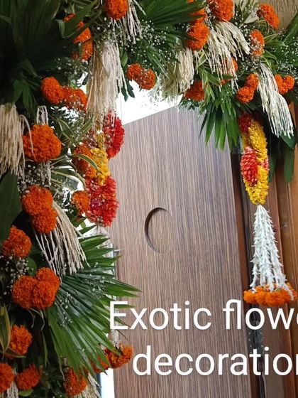 A traditional door decoration using bright orange marigolds and green leaves. The hanging floral tassel adds a classic touch, perfect for festivals and auspicious occasions.