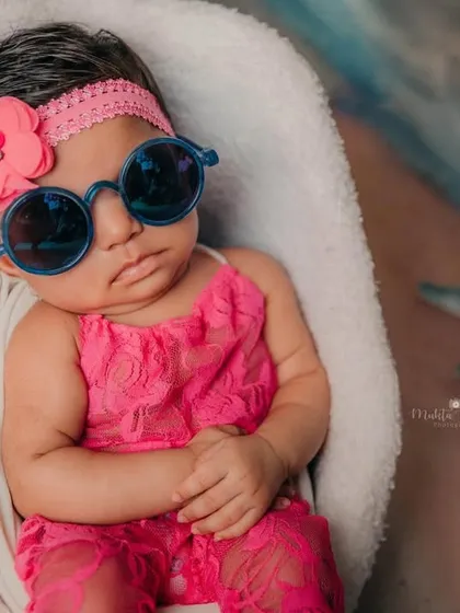 Even the tiniest clients have the biggest personalities. This little one is soaking up the studio beach vibes with her cool sunglasses and adorable pink outfit.