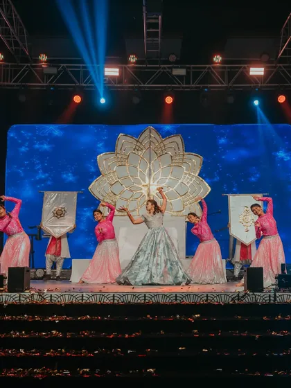 The bride's solo performance on a grand stage, complete with professional backup dancers and a custom-designed backdrop. We coordinate with entertainment artists to create show-stopping acts.