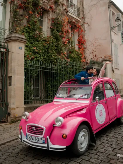 A fun and playful shot of a couple in a bright pink vintage Citroën 2CV on a cobbled Parisian street. This photo is full of personality and captures the charming, whimsical side of the city.