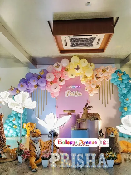 A wide shot of the impressive butterfly jungle setup, showing the full scale of the balloon arch and prop arrangement.