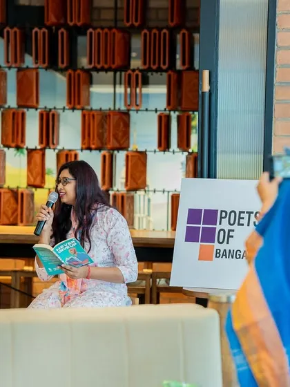 Author Divya G Prasad reads from her debut novel, "Never Give Up," while a proud family member captures the moment. Our events are warm and welcoming to authors' families and friends.