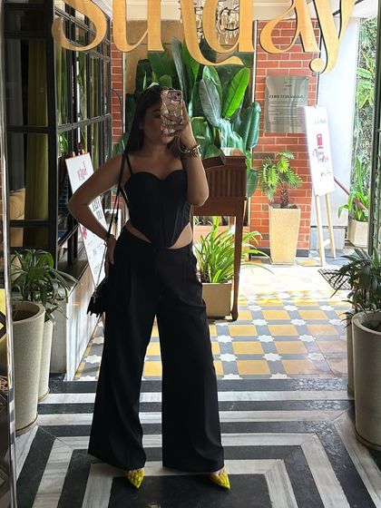 A mirror selfie capturing the full black-on-black outfit, showing how to style a classic look with a modern edge.