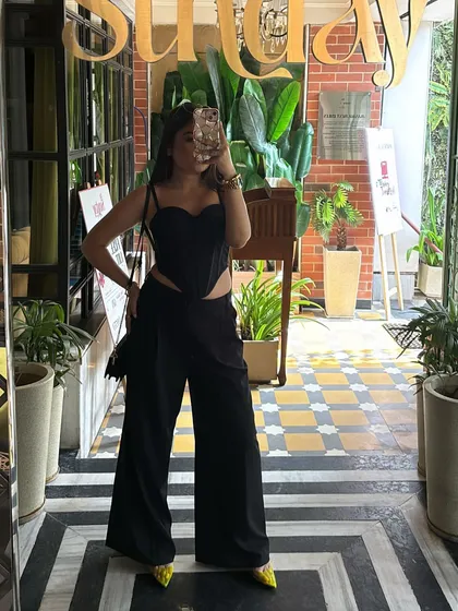 A mirror selfie capturing the full black-on-black outfit, showing how to style a classic look with a modern edge.