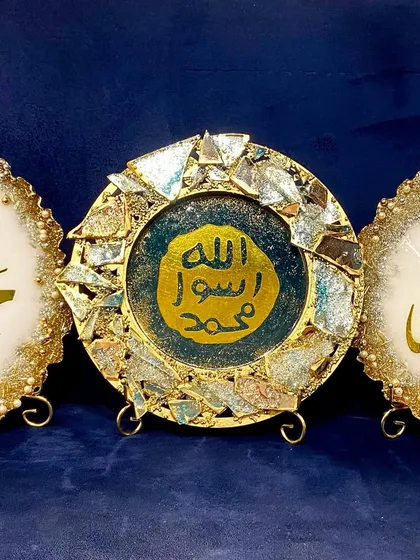 A set of decorative resin plaques featuring the names "Allah" and "Mohammed" in beautiful calligraphy. These pieces can be customized in various colors and styles, like the intricate filigree design or the modern broken-glass effect shown here.