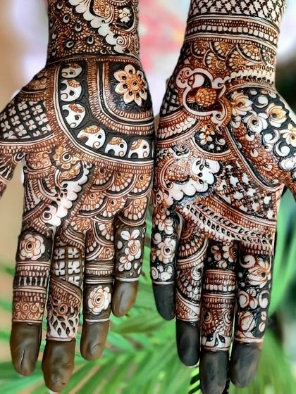 A close-up of intricate palm work, combining floral, paisley, and elephant motifs with a reverse-fill technique for a striking look.