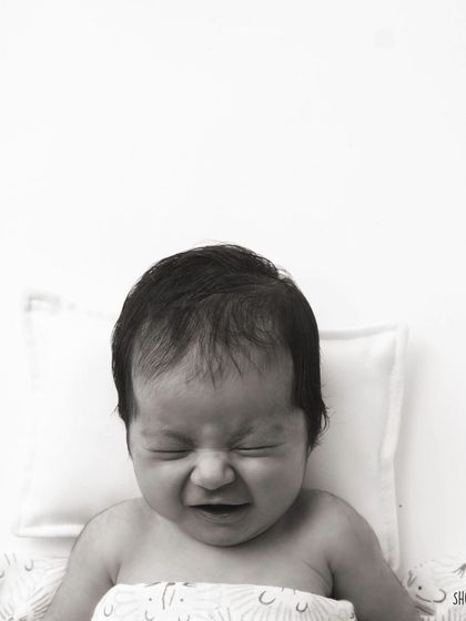 A real, expressive moment from a newborn. Not every photo is a perfect smile, and these authentic expressions are just as precious.