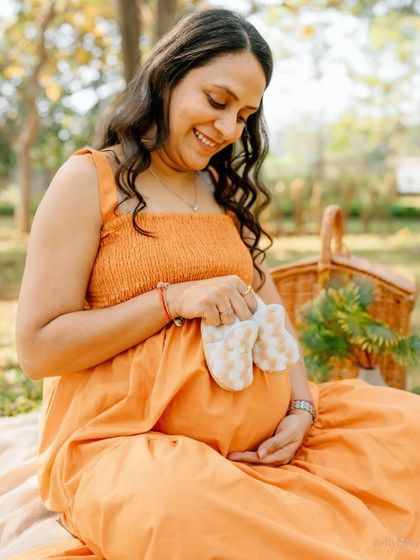 A close-up on those adorable little shoes held against the bump. It's a sweet reminder of the tiny feet that will soon be filling them.
