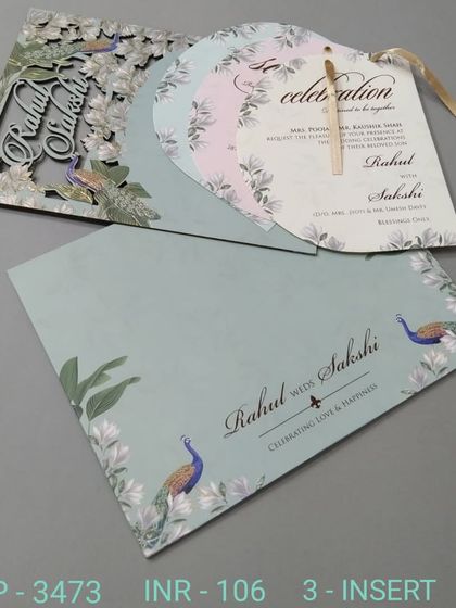 A unique fan-shaped invitation set with a laser-cut cover featuring peacocks and florals. This design is sure to impress your guests with its creative format.