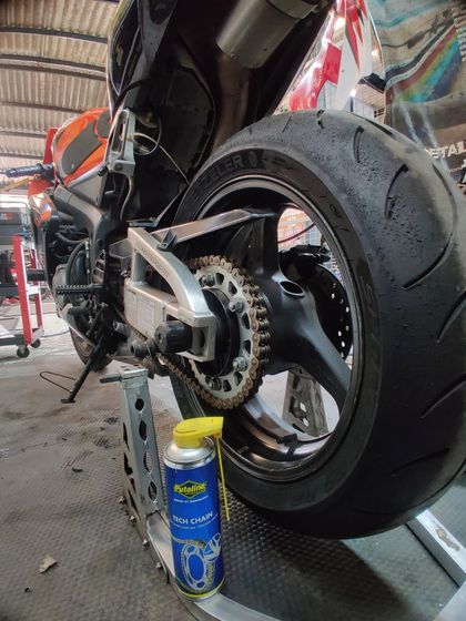 A Honda CBR600RR on the stand getting a chain clean and lube with Putoline products. Basic maintenance is key.