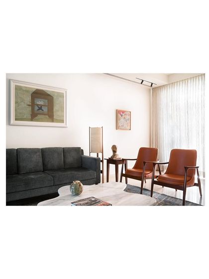 An afternoon view of the living space, where the custom marble coffee table catches the light. The surrounding seating, including the sofa and armchairs, was chosen to create a comfortable and elegant room for relaxing.
